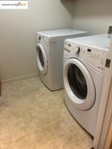 Laundry area with washing machine and dryer and baseboards