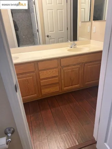 Bathroom with double vanity and wood finished floors