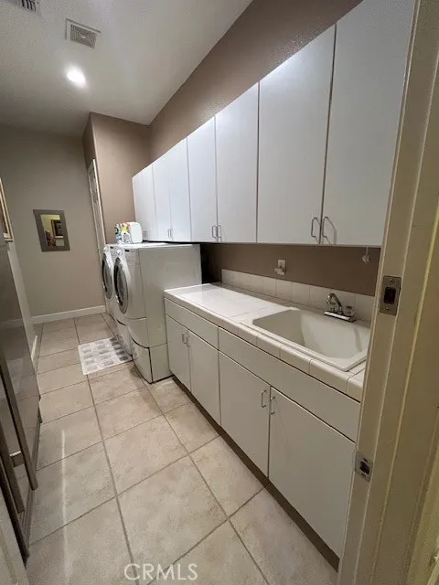 Laundry room with storage cabinets and sink