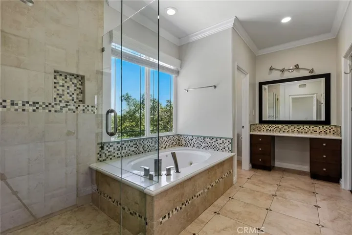 Spacious Primary en-suite bathroom with separate soaking jucazzi tub with view. Rain shower head in shower. Upgraded fixtures for a luxurious experience. Make up area, dual sinks and separate water closet.