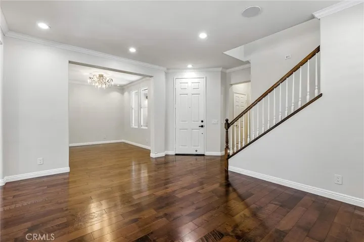 View from living room, dining room, entry door. Rich, warm engineered wood flooring.