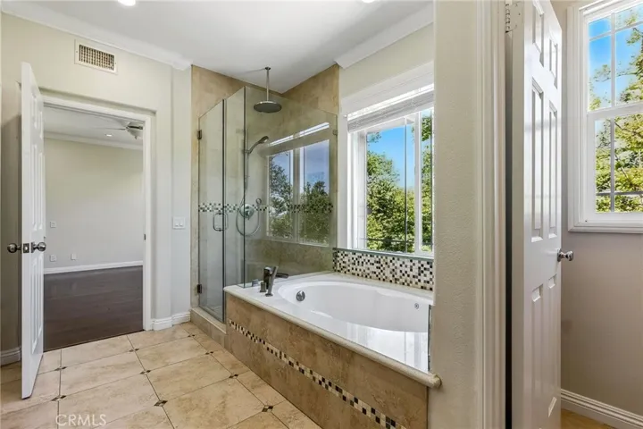View of tub, shower and entry to primary bedroom.