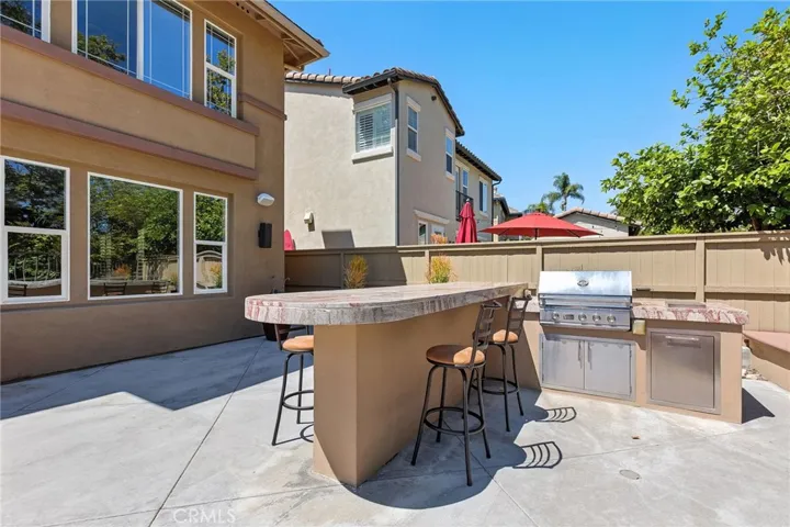 A view of the BBQ with storage. There is also a buffet granite top counter and stainless steel storage drawers and cabinet by the back door.