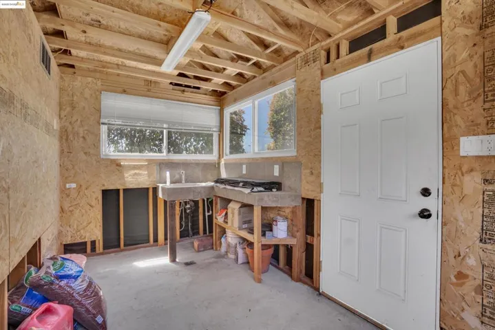 Misc room featuring plenty of natural light and unfinished concrete floors