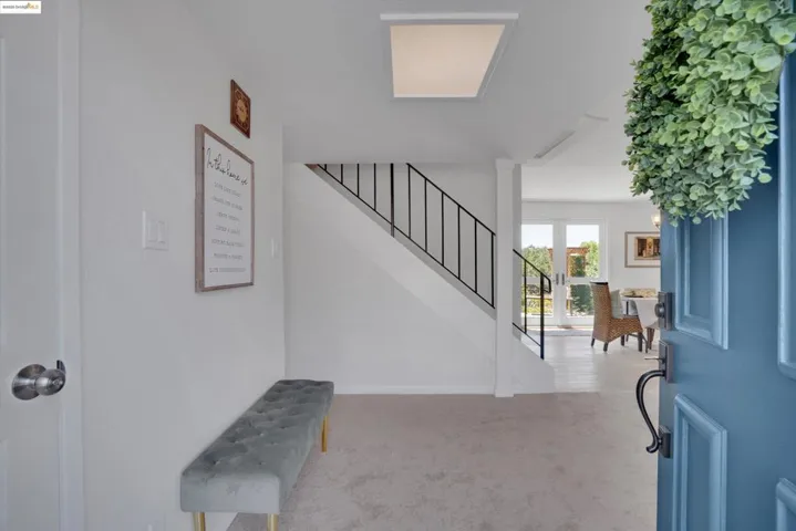 Carpeted entrance foyer with stairway and french doors