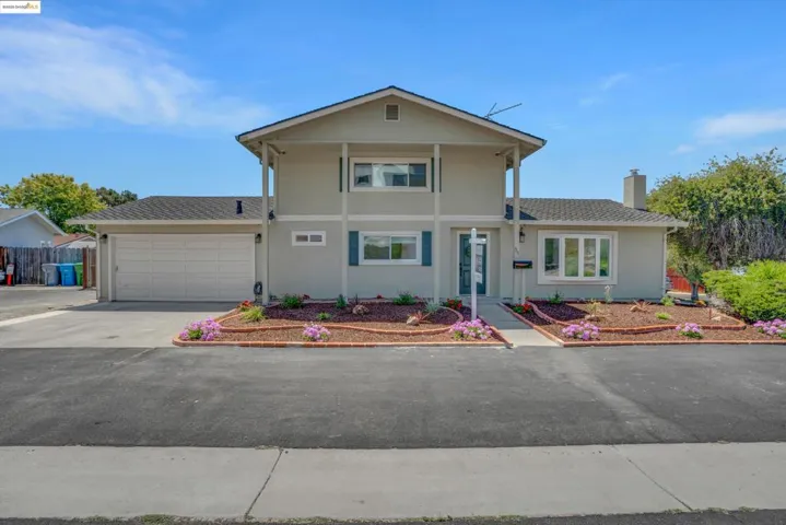 View of front of home with a garage, stucco siding, driveway, and a chimney