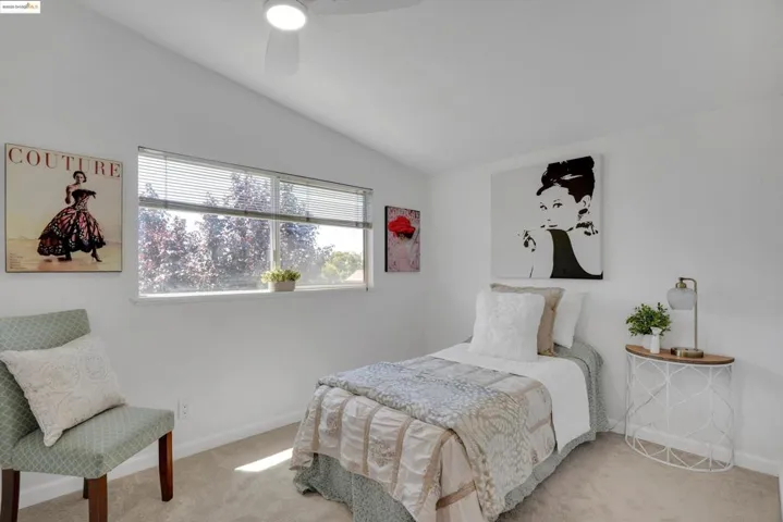 Carpeted bedroom with vaulted ceiling and ceiling fan