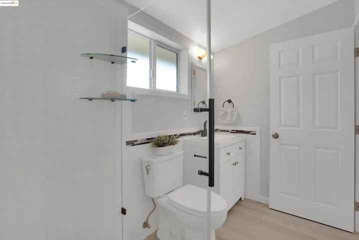 Bathroom with vanity, wood finished floors, and tile walls