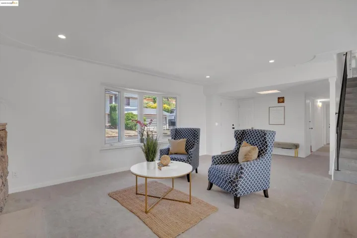Sitting room featuring light colored carpet, recessed lighting, and stairway