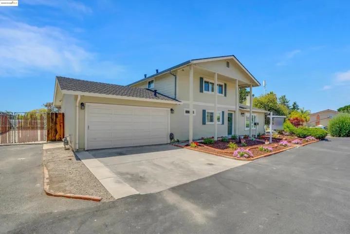 View of front facade featuring an attached garage, driveway, stucco siding, and a shingled roof