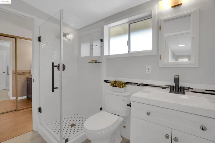Full bathroom with vanity, a stall shower, and wood finished floors