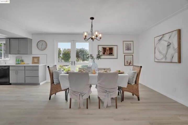 Dining room with light wood-type flooring and a chandelier