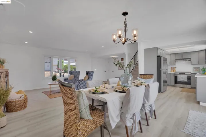 Dining space featuring stairs, light wood-type flooring, a chandelier, and recessed lighting