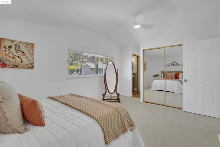 Bedroom featuring vaulted ceiling, carpet flooring, a closet, and ceiling fan