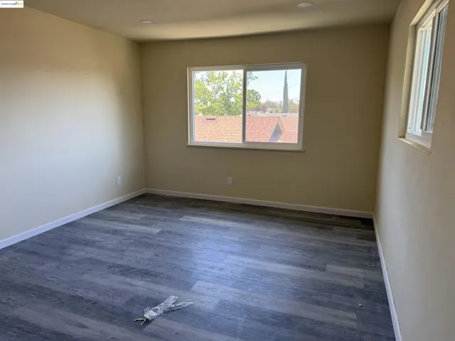Spare room featuring dark wood-type flooring and recessed lighting