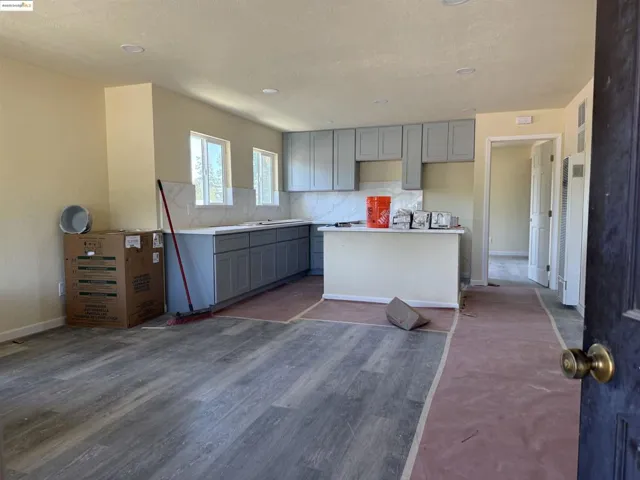 Kitchen with gray cabinets, a kitchen island, backsplash, dark wood-style flooring, and a heating unit