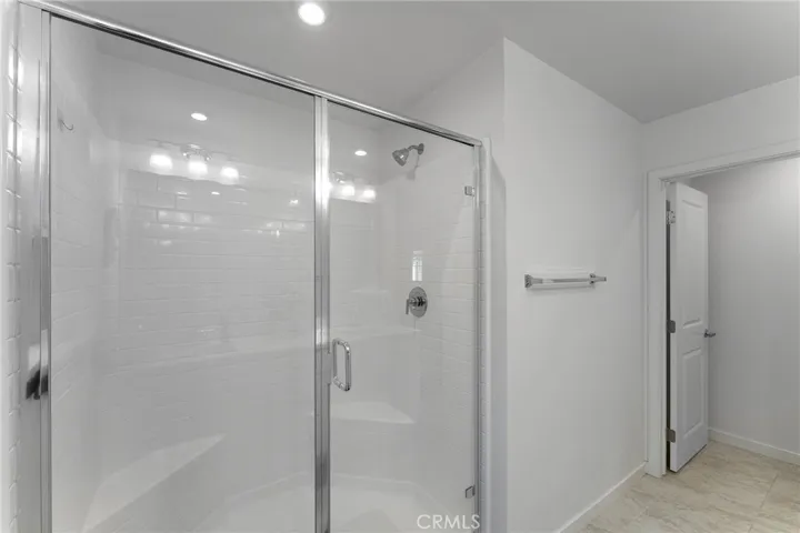 Primary en suite showing the large shower and private commode through the door.