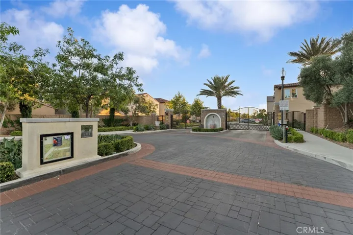 Gated access has a resort feel with palm trees.