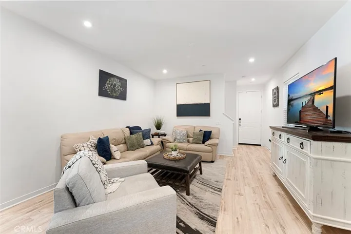 Living room with high ceilings, recessed lighting, LVP flooring. You can add a ceiling fan if desired.