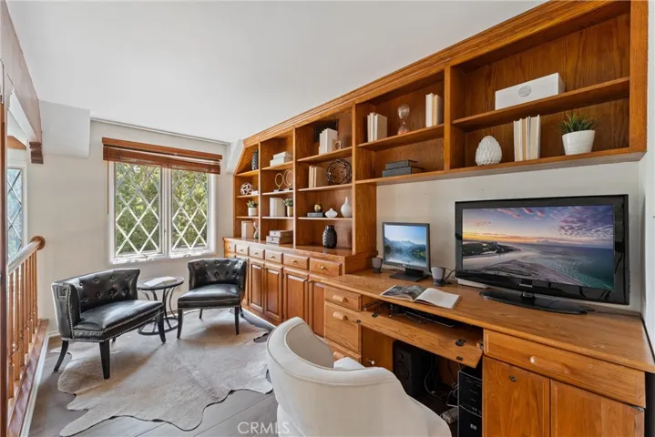 Lofted office with built in bookshelves, overlooks backyard