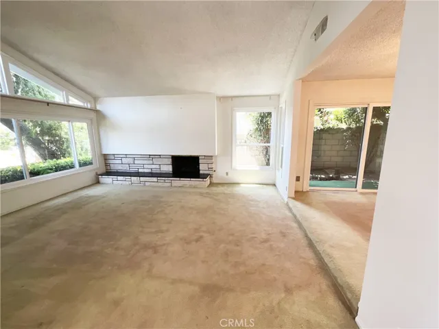 Living Room with Vaulted Ceiling and stone fireplace and hearth...Surrounded by multiple windows allowing for an array of natural light!