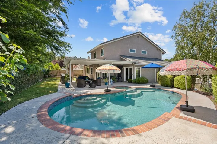 Dreamy yard with sparkling pool and spa, lush landscaping, covered patio, large grass area and so much more!