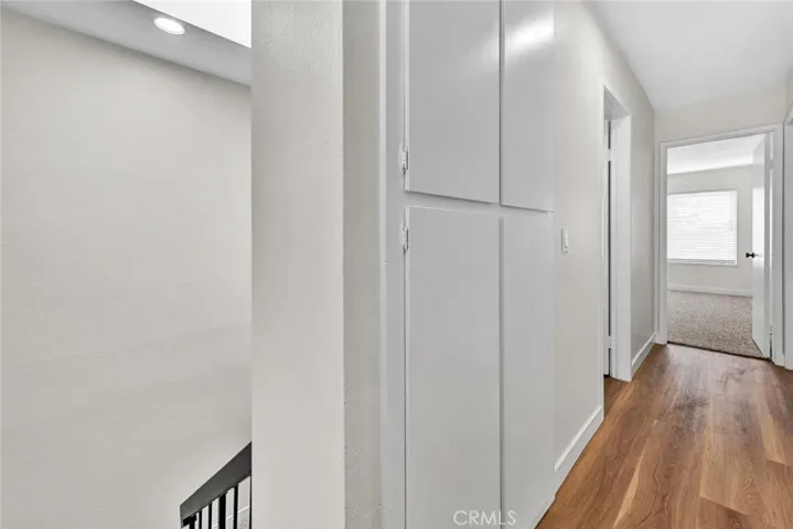 Linen storage upstairs in hallway with new vinyl plank flooring, recessed lighting