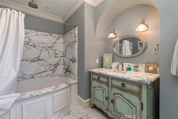 Guest Bathroom with slab marble walls and Perrin and Rowe fixtures.