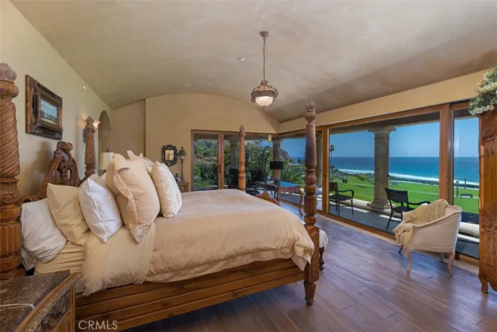 Primary Bedroom with natural white oak flooring. Curved barrel ceiling in hand troweled plaster.  His and Hers Bathrooms in the Primary Suite.  Home has 9 bathrooms.