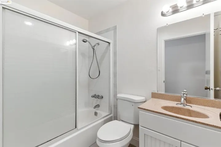 Full bath with shower / bath combination with glass door and vanity