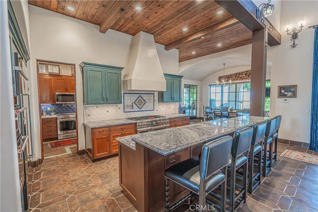 A gourmet’s dream kitchen, outfitted with top-of-the-line appliances, flows seamlessly into the grand living room and informal dining area — perfect for both everyday living and effortless entertaining.