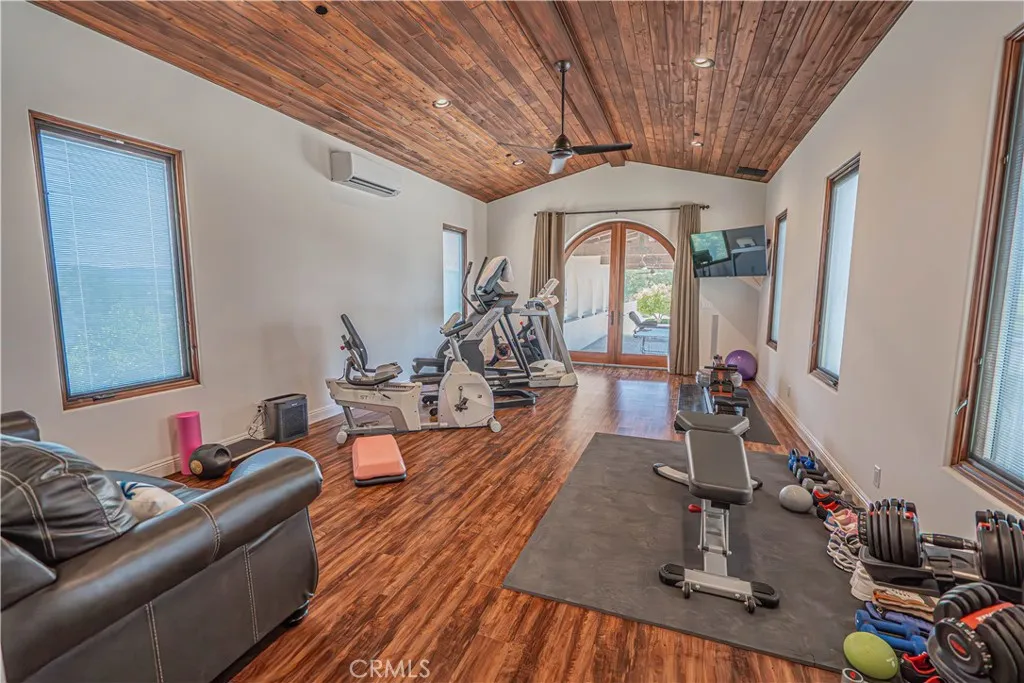 A gorgeous gym with an attached bathroom adds a wonderful touch to this extravagant pool area.