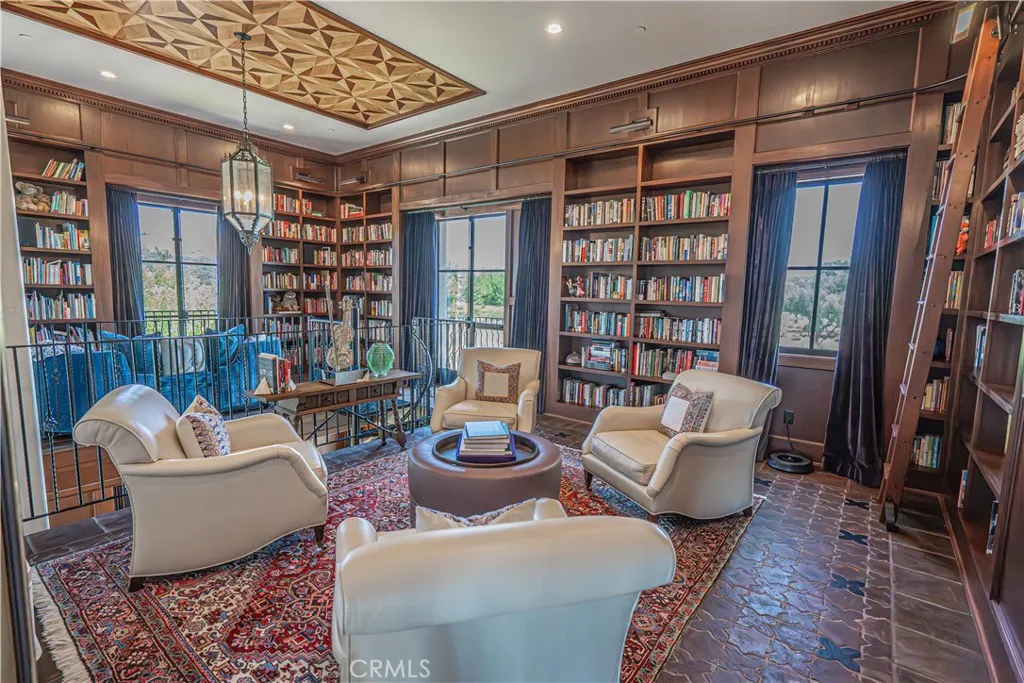 The upper library offers a serene retreat, complete with custom bookshelves and expansive views — perfect for quiet reading and relaxation.