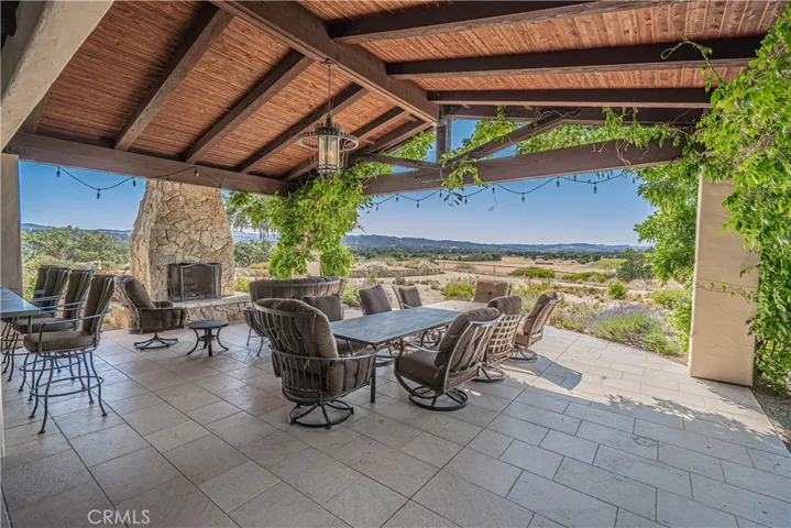 The large covered patio off the BBQ area is perfect for gatherings, complete with a cozy limestone outdoor fireplace.