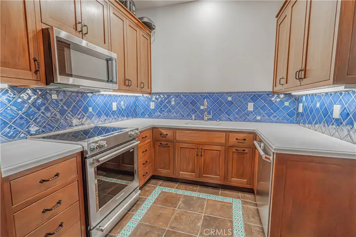 Beyond the main kitchen lies a fully equipped Butler's kitchen, offering an extra oven, cooktop, dishwasher, and microwave — perfect for hosting or keeping the main space clutter-free.