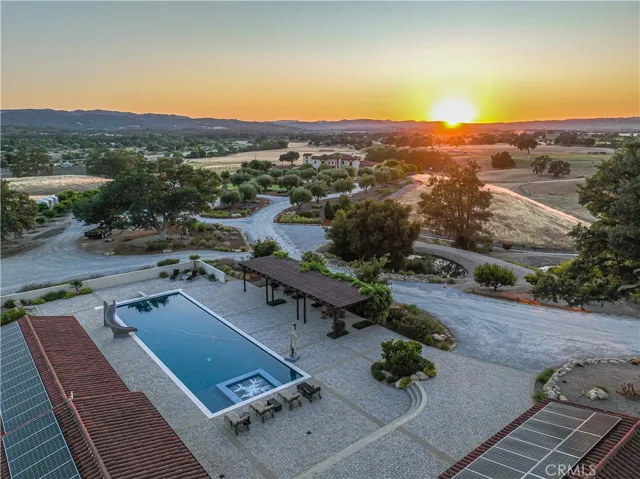 This aerial view showcases the thoughtful separation between the main residence and pool house, enhancing privacy. Strategically placed solar panels on the pool house provide energy efficiency.