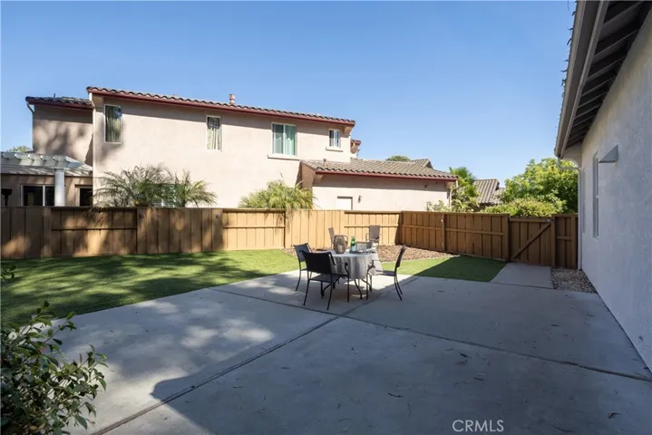 A patio with grass for toys and fun.