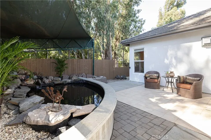 Koi pond with a waterfall and patio seating right outside the master bedroom.