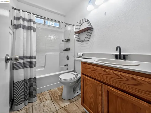 Full bathroom with shower / tub combo and vanity