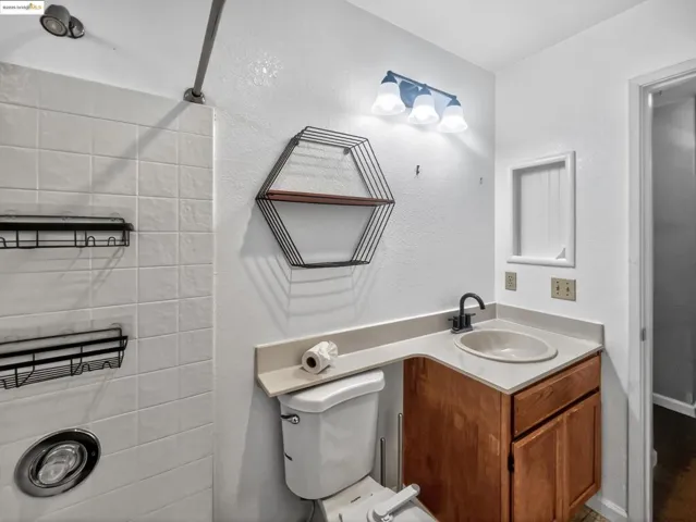 Half bath with vanity and a textured wall