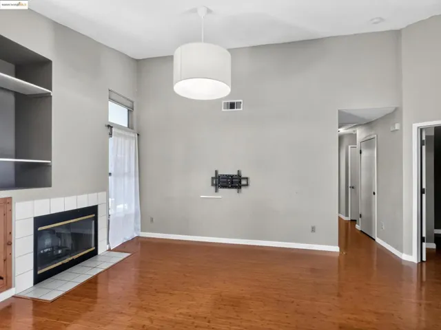 Unfurnished living room featuring a towering ceiling, wood finished floors, and a fireplace