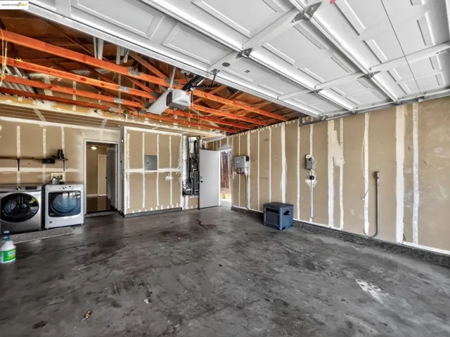 Garage with washing machine and clothes dryer, a garage door opener, and heating unit