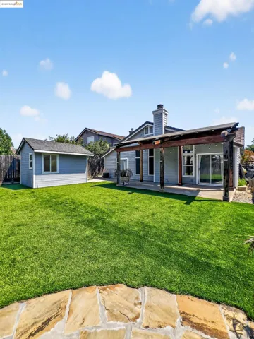 Back of property with a chimney and an outdoor structure