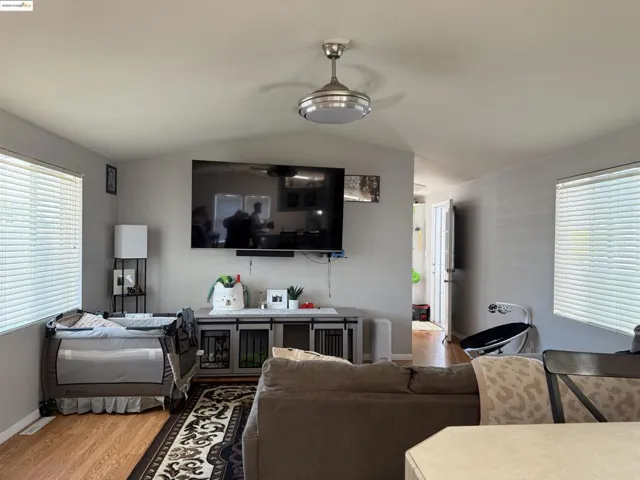 Living room featuring plenty of natural light, wood finished floors, and vaulted ceiling