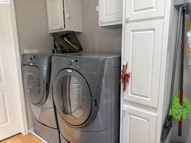 Washroom featuring cabinet space, independent washer and dryer, and light wood-style floors