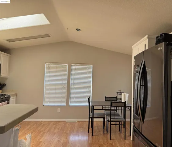 Dining area with vaulted ceiling and light wood finished floors