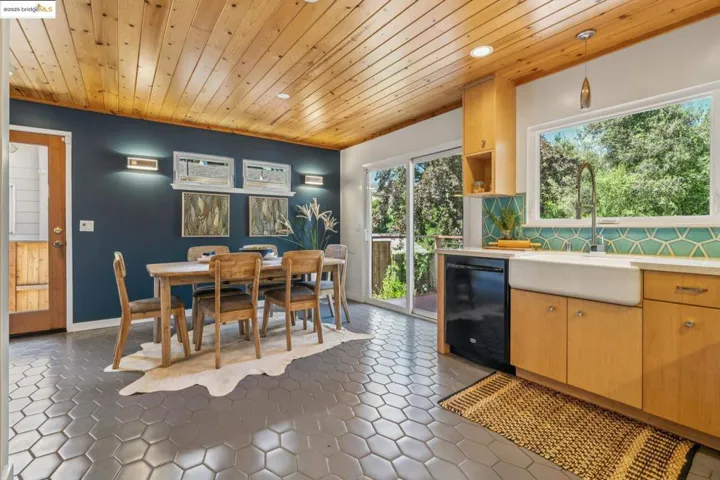 Kitchen featuring wooden ceiling, black dishwasher, light countertops, open shelves, and tasteful backsplash