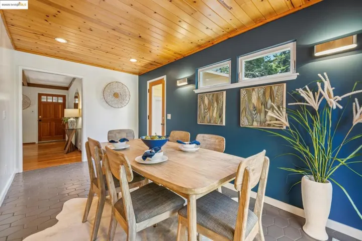 Tiled dining area featuring wood ceiling, recessed lighting, and crown molding