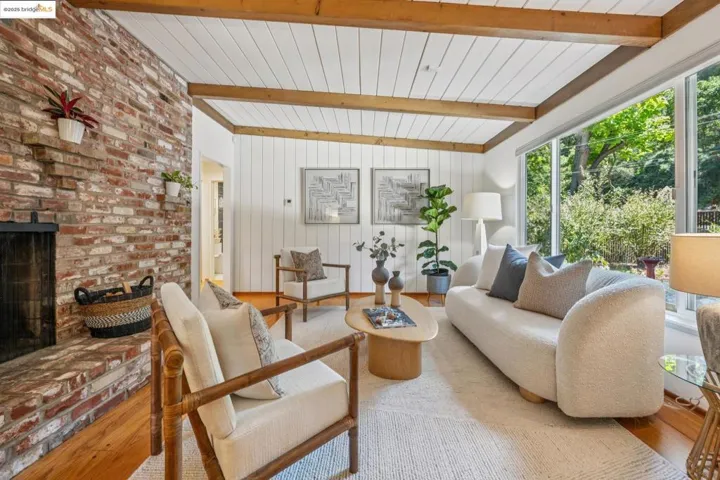 Living area with wood finished floors, a fireplace, a wood ceiling with exposed beams, and wood walls