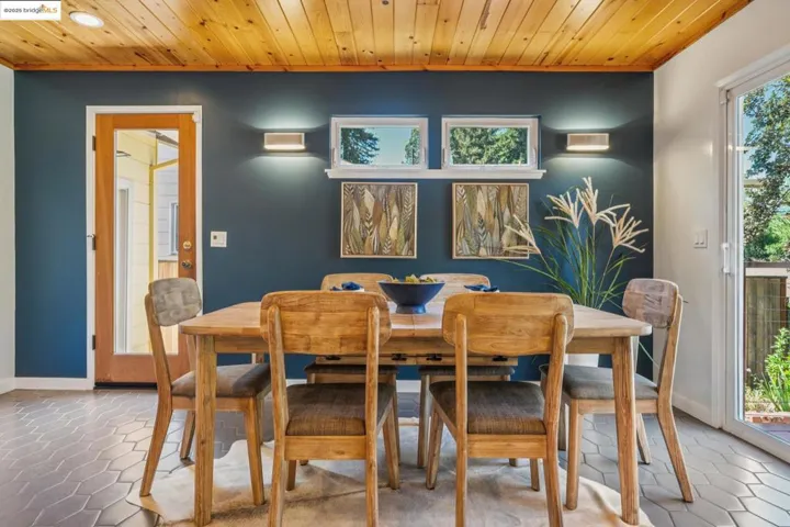 Dining room with wooden ceiling, crown molding, and tile patterned floors
